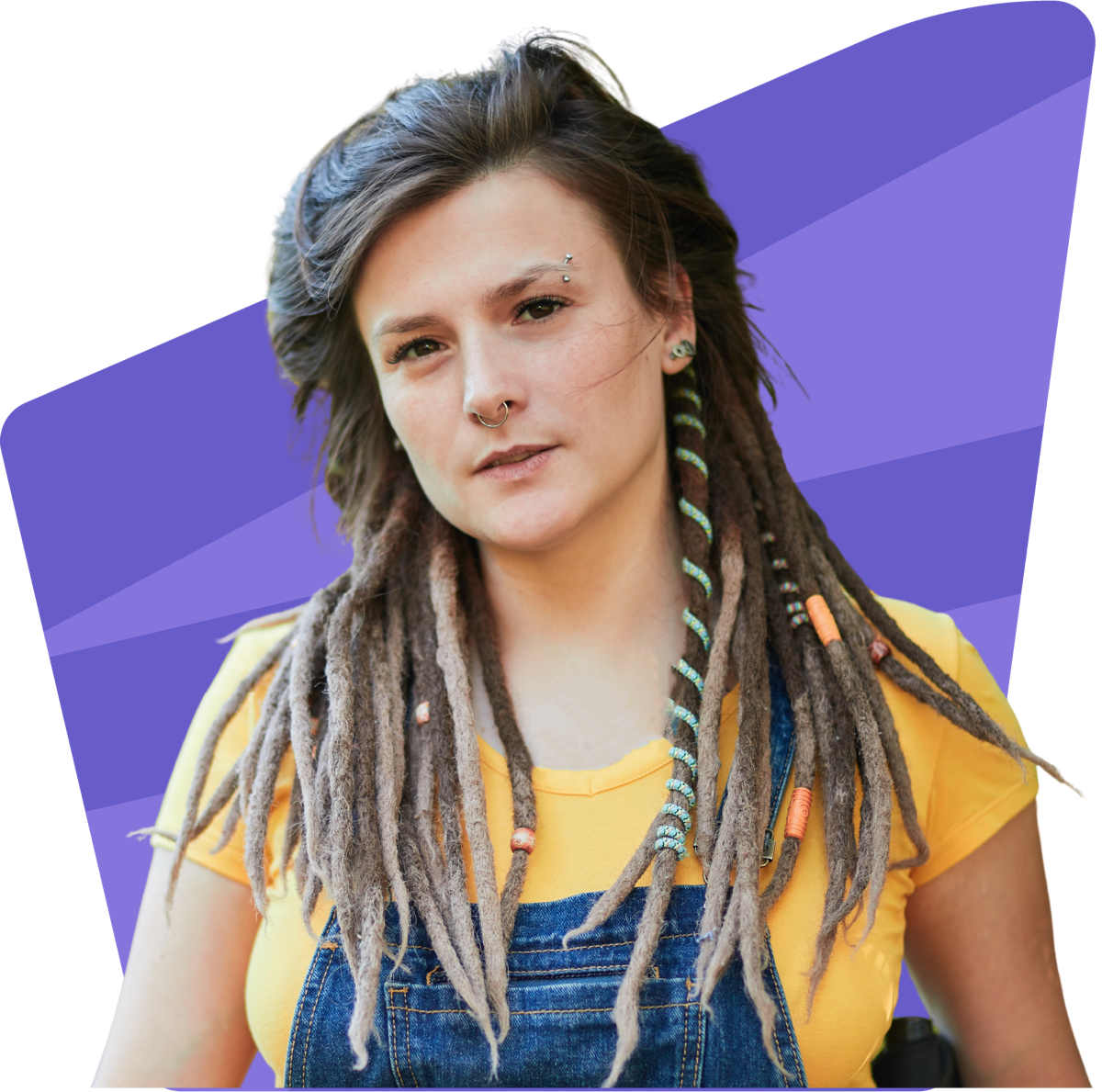 A young woman with dreadlocks wearing a yellow t-shirt and denim overalls